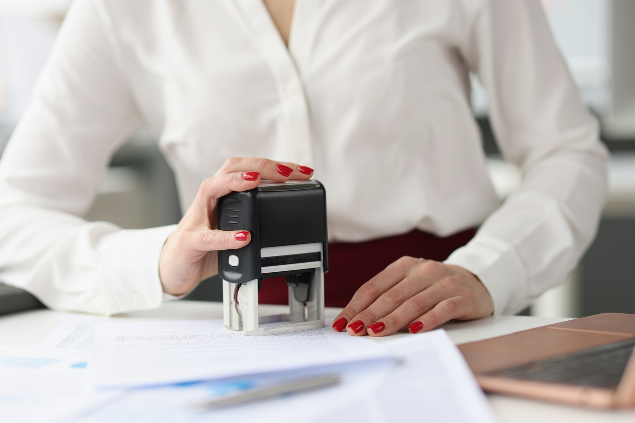 Lady stamping a page with a notary stamp